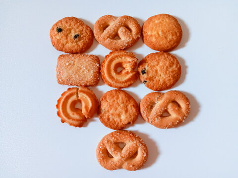Danish butter cookies in variety shapes such as circles, squares, ovals, rings, and pretzel-like forms isolated on white background. Flat lay.