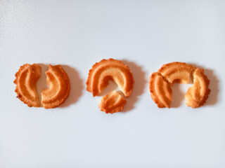Broken Danish butter cookies in ring shapes isolated on white background. Flat lay.