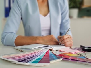 Interior architect designer at workstation table choosing various color samples art tool design...