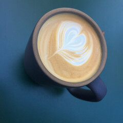 coffee latte art in blue mug on blue background