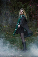 Fototapeta premium Wizard school, student in the magical autumn atmosphere, green and silver colors . Halloween time, masquerade party
