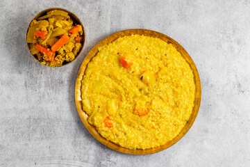 Khichdi is a comforting Indian dish made with rice, lentils, and mild spices, often served as a nourishing, easy-to-digest meal.