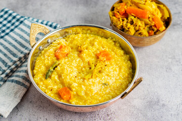 Khichdi is a comforting Indian dish made with rice, lentils, and mild spices, often served as a nourishing, easy-to-digest meal.