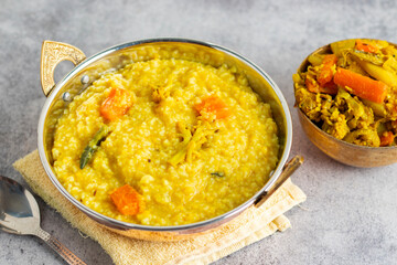 Khichdi is a comforting Indian dish made with rice, lentils, and mild spices, often served as a nourishing, easy-to-digest meal.