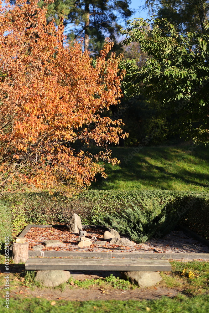 Aufkleber a bench is in a park with a tree in the background. the bench is empty and the tree is full of leave