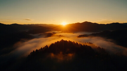 
Sunrise breaking through morning fog over rolling hills, foggy weather, peaceful dawn