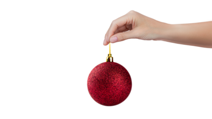 A woman's hand holds a red shiny Christmas tree ball isolated on white or transparent background