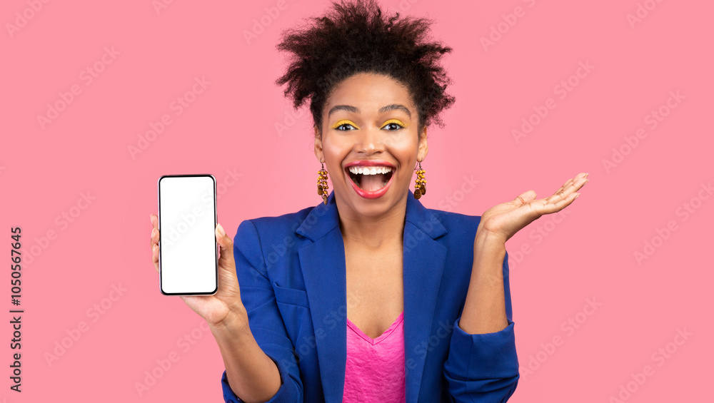 Poster Excited Afro Girl Showing Phone With Empty Screen Smiling At Camera Standing Over Pink Studio Background. Mock up