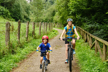 Naklejka premium Mother and child cycling in nature