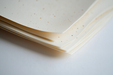 Speckled textured paper sheets close-up in soft lighting