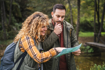 worried hiker couple backpackers try to find route on map