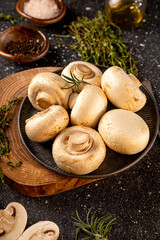 Fototapeta premium Fresh raw champignon mushrooms on gray background vertical photo