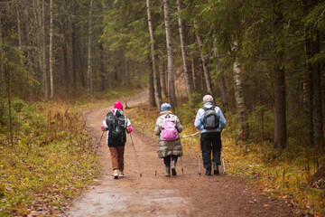 A woman is doing Nordic walking in an autumn park. Doing sports outside.