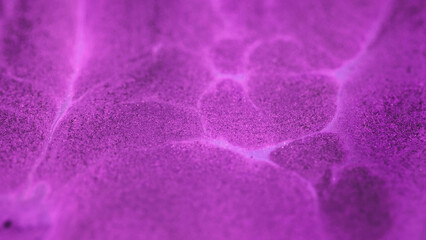 Liquid glitter art. Shiny ink drip. Defocused neon purple pink color shimmering acrylic mix oil spill wet gloss abstract background.