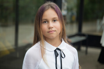 Fototapeta premium A schoolgirl girl on a city street.A schoolgirl goes to school.