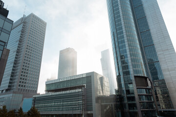Obraz premium Beautiful modern metropolis in the fog with business and office buildings and the Palace of Culture in Warsaw. Amazing foggy city of Warsaw with sun, Poland on a cloudy, overcast day. Urban wallpaper