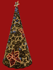Large narrow Christmas tree with ladies and Christmas tree lights on red background with copy space