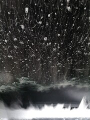 Rotating brush in the car wash against the windshield of the car. Seen from inside and very close.