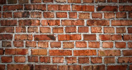 Fototapeta premium Panorama of red old brick wall. Detailed texture of aged masonry with broken bricks and peeling plaster. Urban, grunge, industrial, abstract backdrop. Pattern of loft interior or exterior background