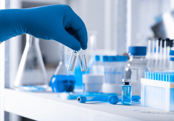 A scientist's hand in a medical glove holds a test tube