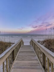 Fototapeta premium Wooden Boardwalk Leading to the Beach at Sunset
