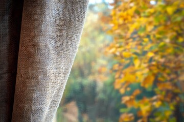 Earthy autumn background with a natural burlap curtain, rich fall colors, and soft lighting, giving a warm, rustic feel