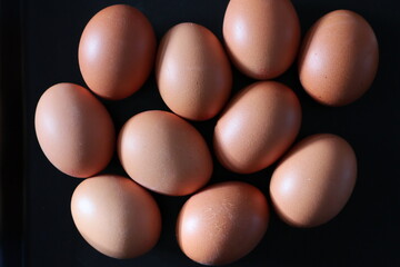 Brown eggs on black background