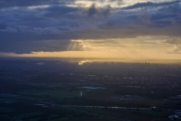 Amsterdam in the morning sun from the plane with lots of clouds
