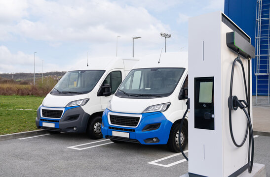 Fototapeta Electric delivery vans with electric vehicles charging station