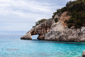 Fototapeta premium Cala Goloritze. Awesome crystal clear Mediterranean sea at the eastern coast of Sardinia, Italy. Turquoise emerald water and gorgeous cliffs. Baunei area, Sardinia.