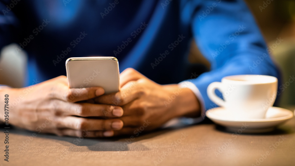 Poster new useful application. unrecognizable black man using cellphone sitting at table in cafe, having co