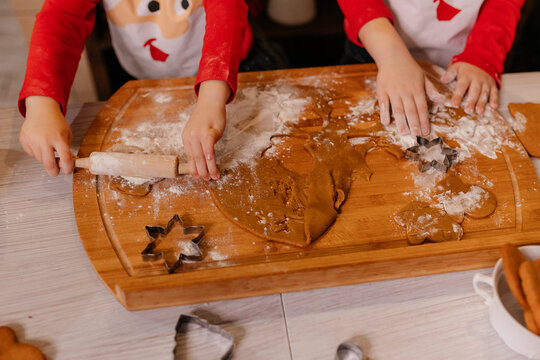 Cooking Christmas cookies with family. Father Mother and daughter hands top view on making gingerbread biscuits with cookie cutters, with New Year Christmas decoration