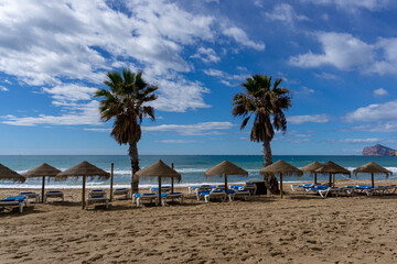 Playa de Calpe con sombrillas y palmeras