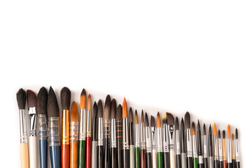 Fototapeta premium Mix of paint brushes in a row isolated on a white background.