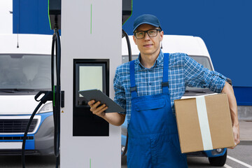 Delivery man in uniform with digital tablet next to electric van