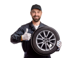 Smiling mechanic holding car tire and showing thumbs up on transparent background
