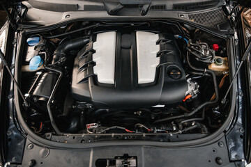 Car with open hood close up to camera. Maintenance in auto repair shop. Car service, repair, maintenance concept. Selective focus.