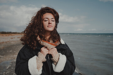 Young woman walking on lake shore on autumn day