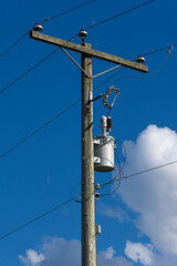 An image of a tall wooden power pole with power transformer for power distribution in rural areas. 