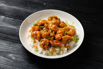 Chinese orange chicken with rice and green onion garnish