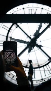 Paris, France: Orsay Museum Clock with silhouette of tourists taking picture