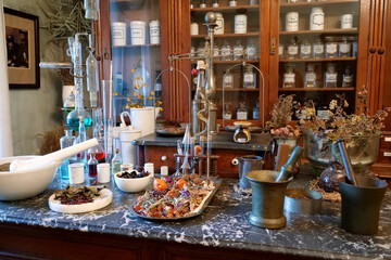 Chemistry flasks with liquids, herbs of medicinal plants in an old pharmacy