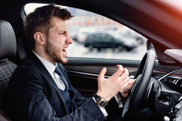 Angry Driver Concept. Aggressive mad man in suit driving car in urban city, angrily gesturing