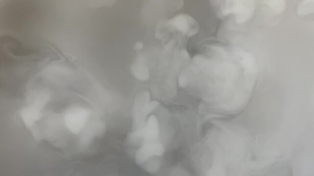 Swirling smoke or steam creating abstract patterns on a gray background