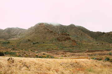 Trockenes Tal mit Terrassenfeldern und Nebel in den Bergen, Teneriffa
