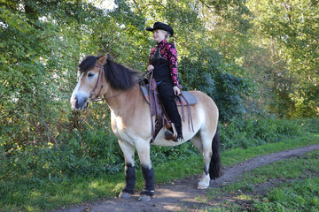Westernreiten - Reiterin mit Cowboyhut mit Ihrem Pferd