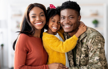 Portrait Of Happy Military Family, Black Soldier Father, Wife And Little Daughter Embracing...