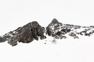 Two high rocky cliffs between which snow has gathered