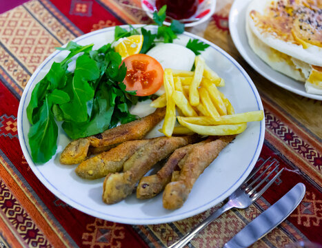 Deep fried red mullet with vegetable garnish served in authentic Turkish restaurant.