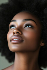 Fototapeta premium A young woman with voluminous natural hair looks contemplatively toward the ceiling, radiating calmness and beauty in soft lighting